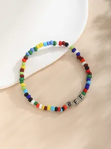 Detalle macro de la pulsera de cuentas de colores BFF sobre fondo neutro con textura