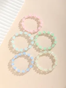 Detalle de cinco pulseras de cuentas de vidrio esmerilado en colores pastel macaron
