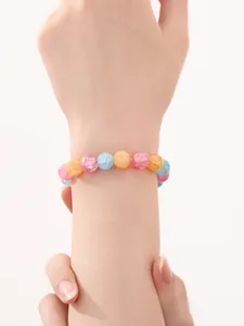 Detalle de pulsera de cuentas de vidrio craquelado multicolor usada en una toma de primer plano