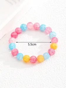 Detalle de una pulsera de cuentas coloridas con textura de grietas en rosa, azul y amarillo