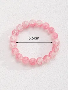 Detalle de pulsera de cuentas rosas con medida de 5,5 cm de diámetro interior y textura fina