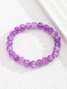 Detalle de pulsera de cuentas moradas que muestra textura translúcida y grietas de hielo