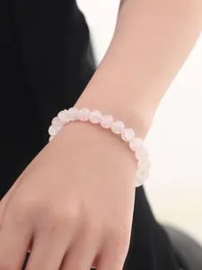 Primer plano detallado de la pulsera de cuentas de cuarzo rosa con textura de piedra