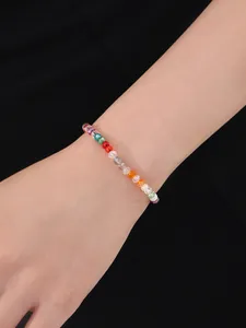 Primer plano de una pulsera de cuentas de cristal de colores en la muñeca de una modelo