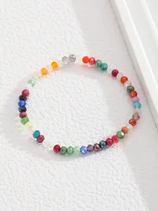 Primer plano de cuentas de vidrio facetado de colores en una pulsera elástica moderna