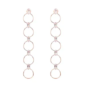Detalle de pendientes lineales de oro rosa con círculos huecos y circonitas cuadradas