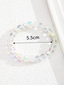 Detalle de pulsera de cuentas iridiscentes con diámetro interior de 5,5 cm sobre blanco