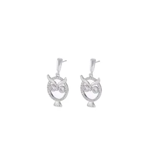 Dettaglio degli orecchini a forma di civetta in argento con brillanti zirconi cubici
