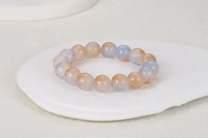 Vista detallada de la pulsera de cuentas de vidrio coloridas con destellos azules y naranjas