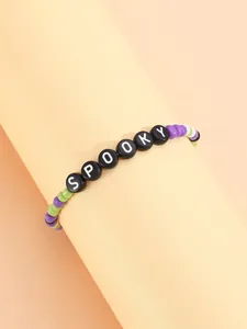Primer plano de pulsera de cuentas de Halloween con letras SPOOKY y detalles lilas