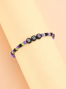 Detalle de una pulsera elástica de Halloween con cuentas de color púrpura, verde y letras BOO