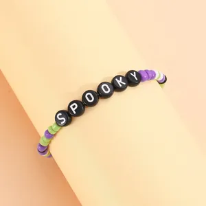 Pulsera de Halloween con cuentas de colores y letras Spooky sobre fondo naranja suave