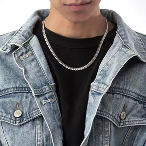 Close-up of a silver stainless steel Cuban link chain necklace worn on a male model