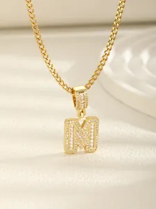 Détail du pendentif lettre M plaqué or 18k avec zircons sur une chaîne cubaine