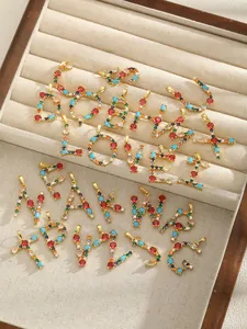 Detailed view of 26 colorful zircon alphabet pendants A-Z with golden plating on velvet