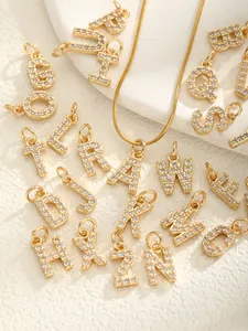 Détail du collier avec pendentif lettre doré serti de cristaux de zircone cubique