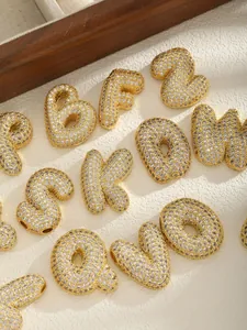 Macro shot of 26 chunky gold-plated letter pendants with micro-paved cubic zirconia