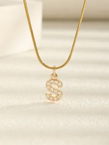 Vue macro détaillée du collier avec pendentif lettre S doré orné de zircons étincelants