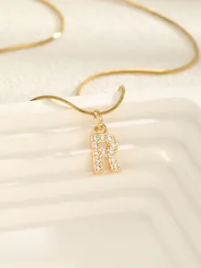Détail du pendentif lettre R doré avec zircons et sa fine chaîne serpent élégante