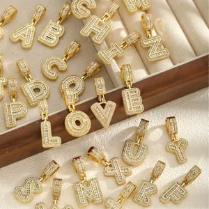 Pendentifs alphabet A-Z dorés à l'or 18k sertis de zircons sur support en velours beige