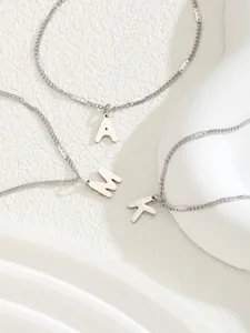 Primer plano de collares de acero inoxidable plateado con colgantes de letras AMK