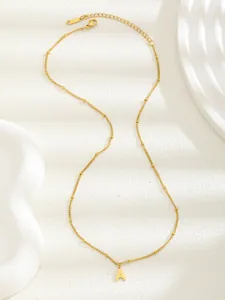 Detalle del collar de acero inoxidable dorado con colgante letra A y cierre de mosquetón