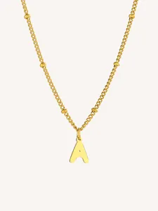 Detalle del collar dorado con colgante de la letra A y cadena de eslabones con cuentas