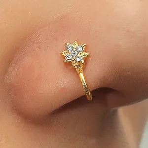 Golden star-shaped nose stud with sparkling cubic zirconia on a female model