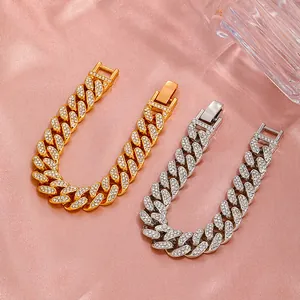 Dettaglio di bracciali a catena cubana argento e oro con strass scintillanti