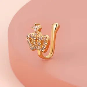 Close-up of golden crown nose cuff with sparkling zircon inlay on pink prop