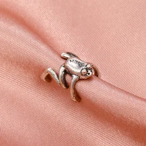 Vintage punk silver frog ear cuff with detailed oxidation finish on pink silk backdrop