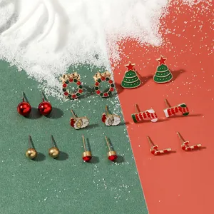 8-pair set of Christmas stud earrings with reindeer and Santa designs on festive snow backdrop