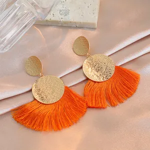 Bohemian gold hammered metal fan earrings with long vibrant orange thread tassels