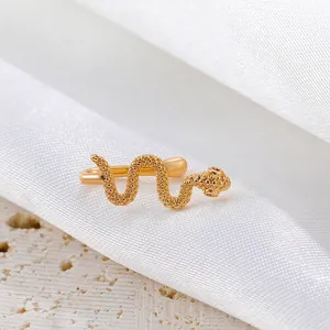Macro shot of gold snake ear cuff detailing intricate scale texture on silk background