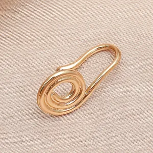 Vue macro d'un clip de nez en U or rose sur un fond de soie texturé champagne