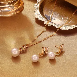 Elegantes spiralförmiges Perlen-Schmuckset in Gold mit glänzenden Zirkonia-Steinen