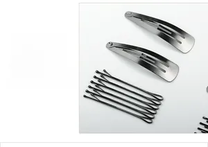 Detail view of matte black metal bobby pins and drop-shaped snap clips set on white background