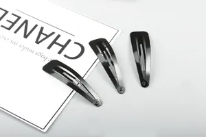 Close-up of three glossy black metal hair clips with smooth finish for bridal styling