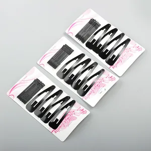 Set of black metal snap hair clips and bobby pins on floral decorative cardboards