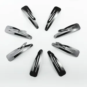 Set of 8 minimalist black metal snap hair clips arranged in a creative circular pattern