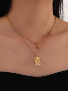 Close-up of layered gold Gemini zodiac necklace set with tarot style pendant on model
