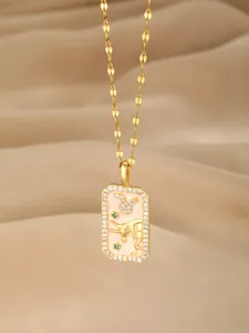 Makro-Detail des goldenen Stier-Anhängers mit rosa Emaille und weißen Zirkonia-Steinen