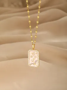 Nahaufnahme der goldenen Schütze-Halskette mit rosa Emaille und funkelnden Zirkonen