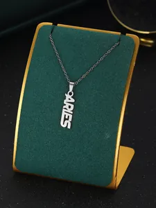 Detailed view of silver Aries letter pendant on green velvet jewelry stand