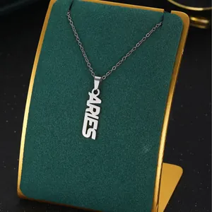 Silver Aries zodiac pendant necklace with hollow vertical lettering on a display stand