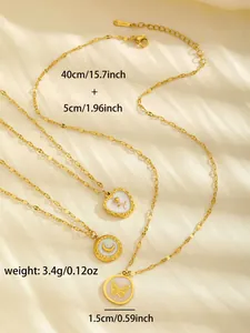 Detail of gold-plated stainless steel shell pendants with moon and rose designs on silk