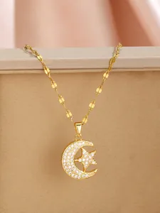 Detailed view of a gold moon and star pendant necklace with cubic zirconia on a silk base