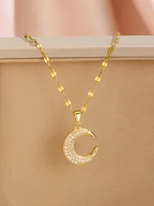 Detail of a crescent moon pendant with white zircons on a gold twisted chain necklace