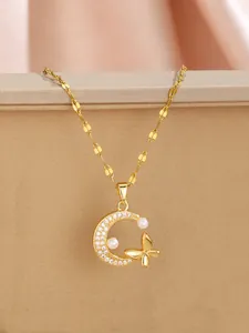 Detailed close-up of golden crescent moon pendant with zircon stones and tiny butterfly