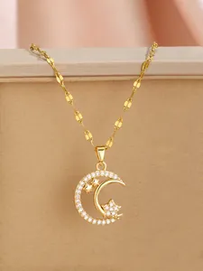 Macro detail of gold star and moon pendant necklace with zircon inlay on jewelry box